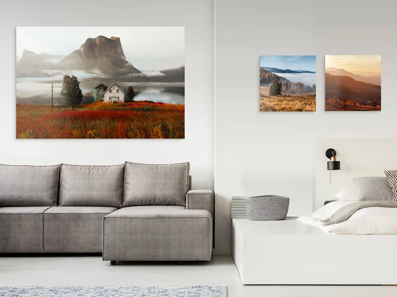 One large and two small landscape photos as photo prints hanging on a wall under matte acrylic glass.