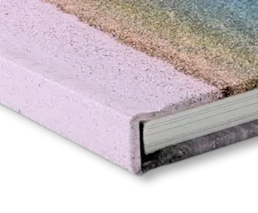 Close-up view of a pink hardcover book spine and pages, showing textured cover material and white paper edges.