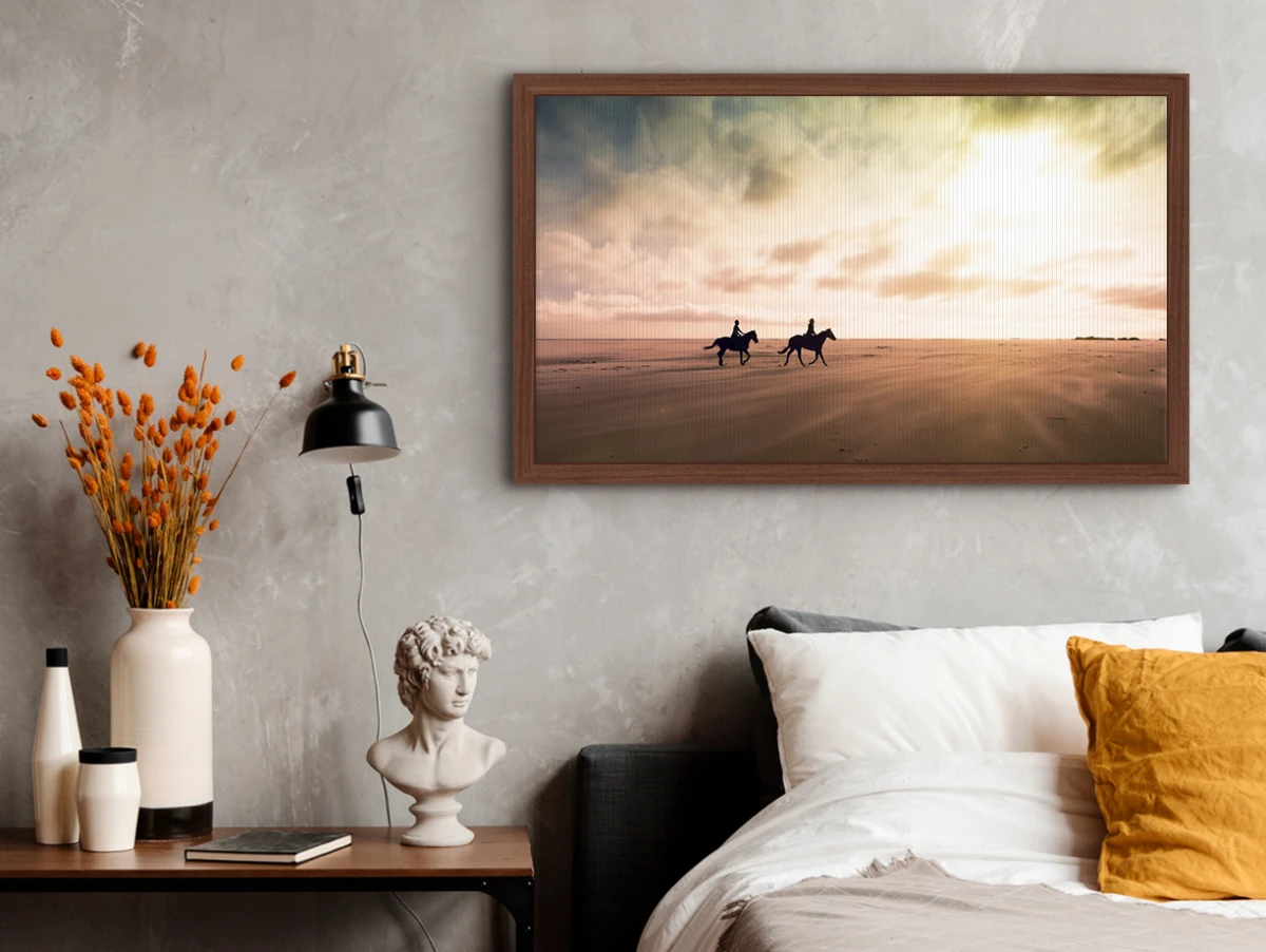 two horse riders in the desert as a textile print in a solid wood floater frame hanging on a wall.
