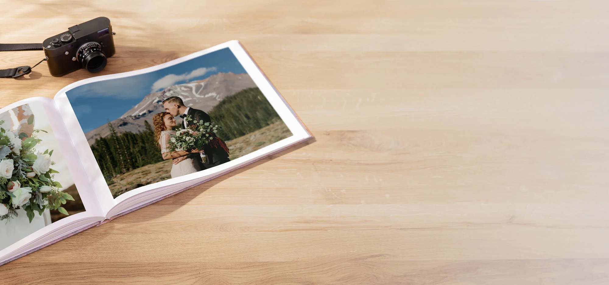 Wedding photo album on wooden table showing bride and groom walking and floral bouquet visible.