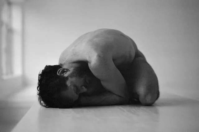 black and white portrait of a man sitting on a table by David Szubotics.