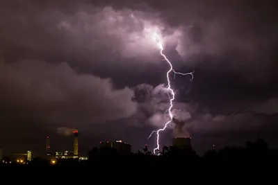 Lightning striking over a city at night.