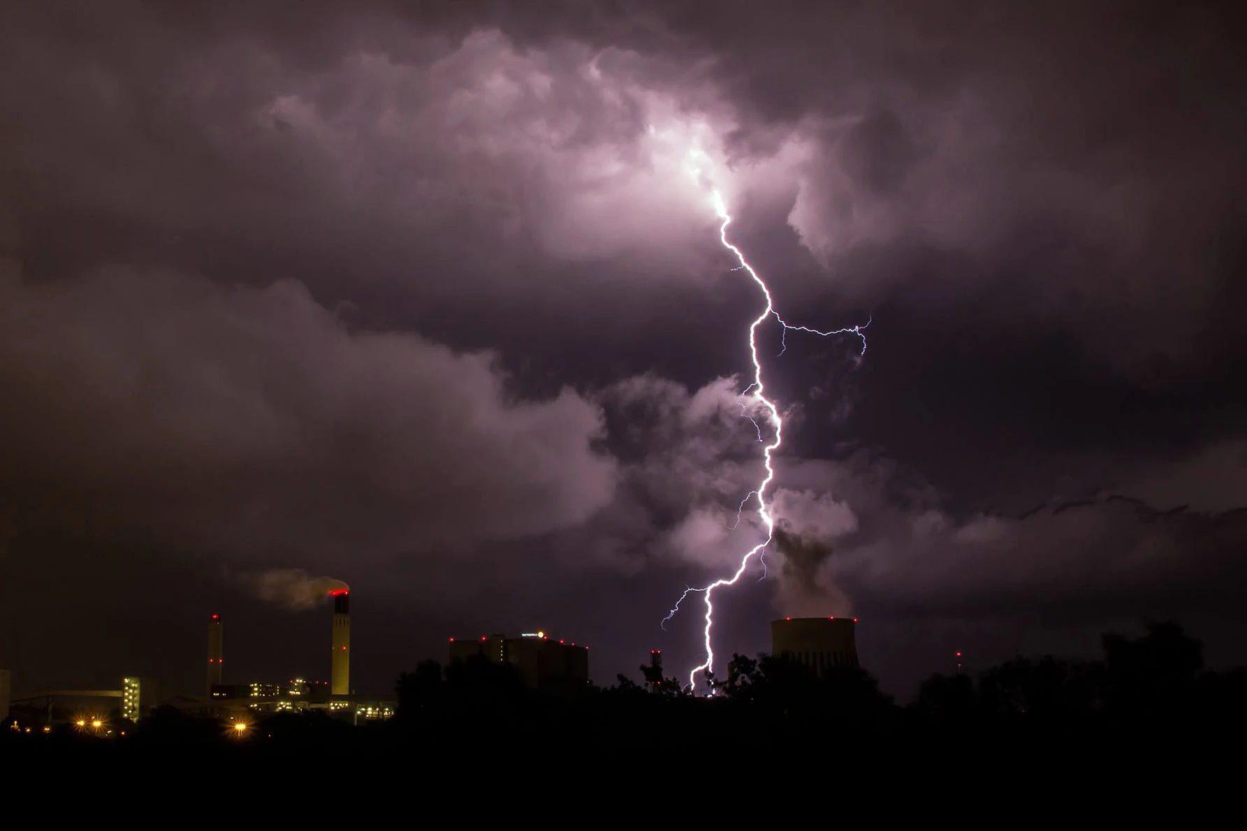 Lightning striking over a city at night.