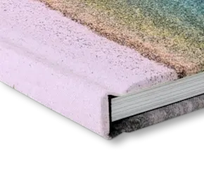 Close-up view of a pink hardcover book spine and pages, showing linen cover material and white paper edges.