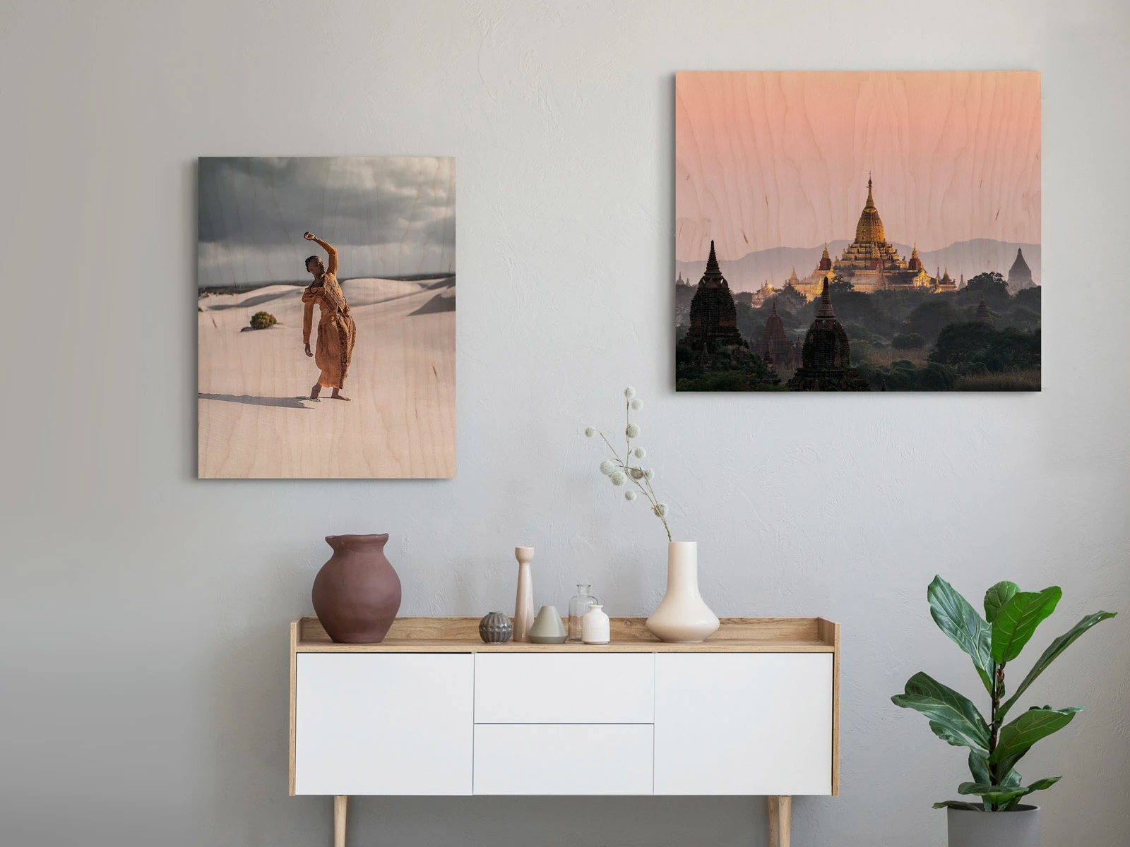 Two motifs on Direct Print On Wood on a wall in a living room. One with a person stands in front of sand dunes in a desert and one with a temple in the sunset.