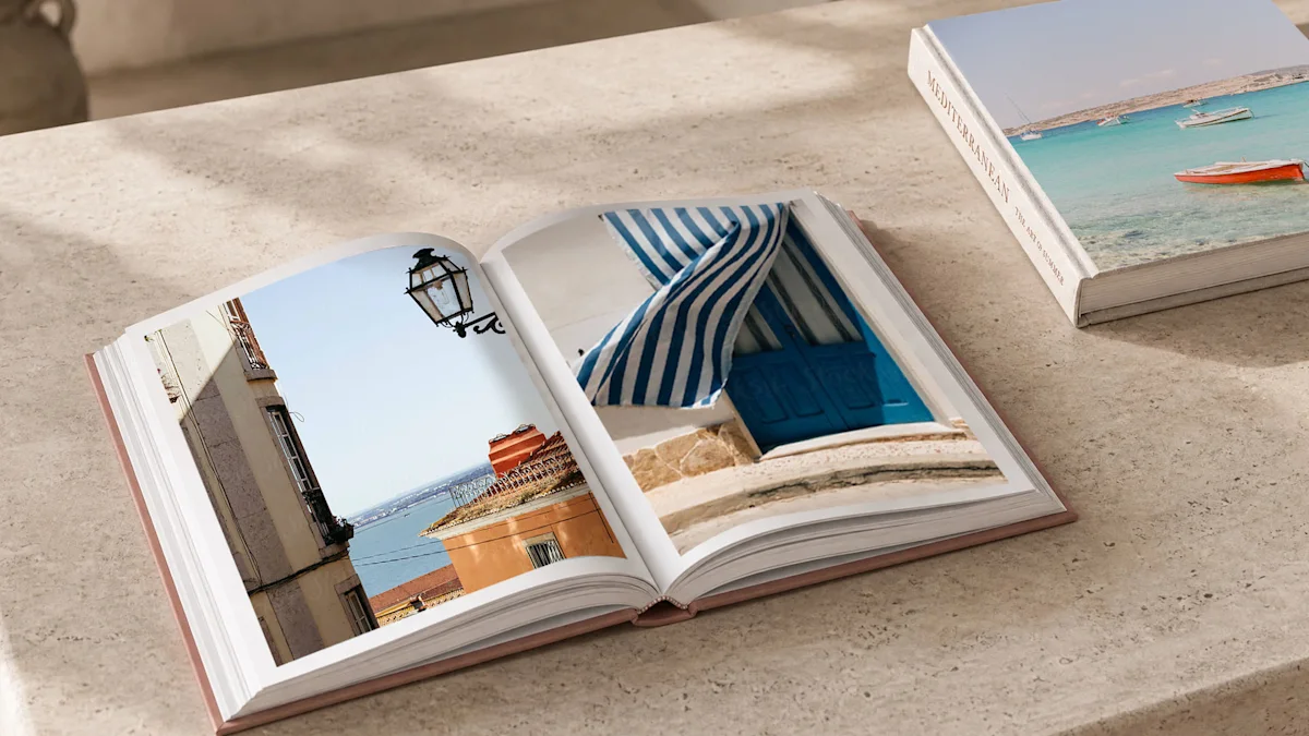 Vista superior de un libro de fotografía premium abierto con una tapa dura de color salmón, apoyado sobre una superficie de piedra de travertino claro. La página izquierda muestra una fotografía vertical de una persona leyendo un libro sobre una toalla de playa a rayas azules y blancas. La página derecha presenta un primer plano cuadrado de un pomelo cortado con el océano turquesa de fondo. El diseño minimalista resalta la impresión editorial de alta gama.