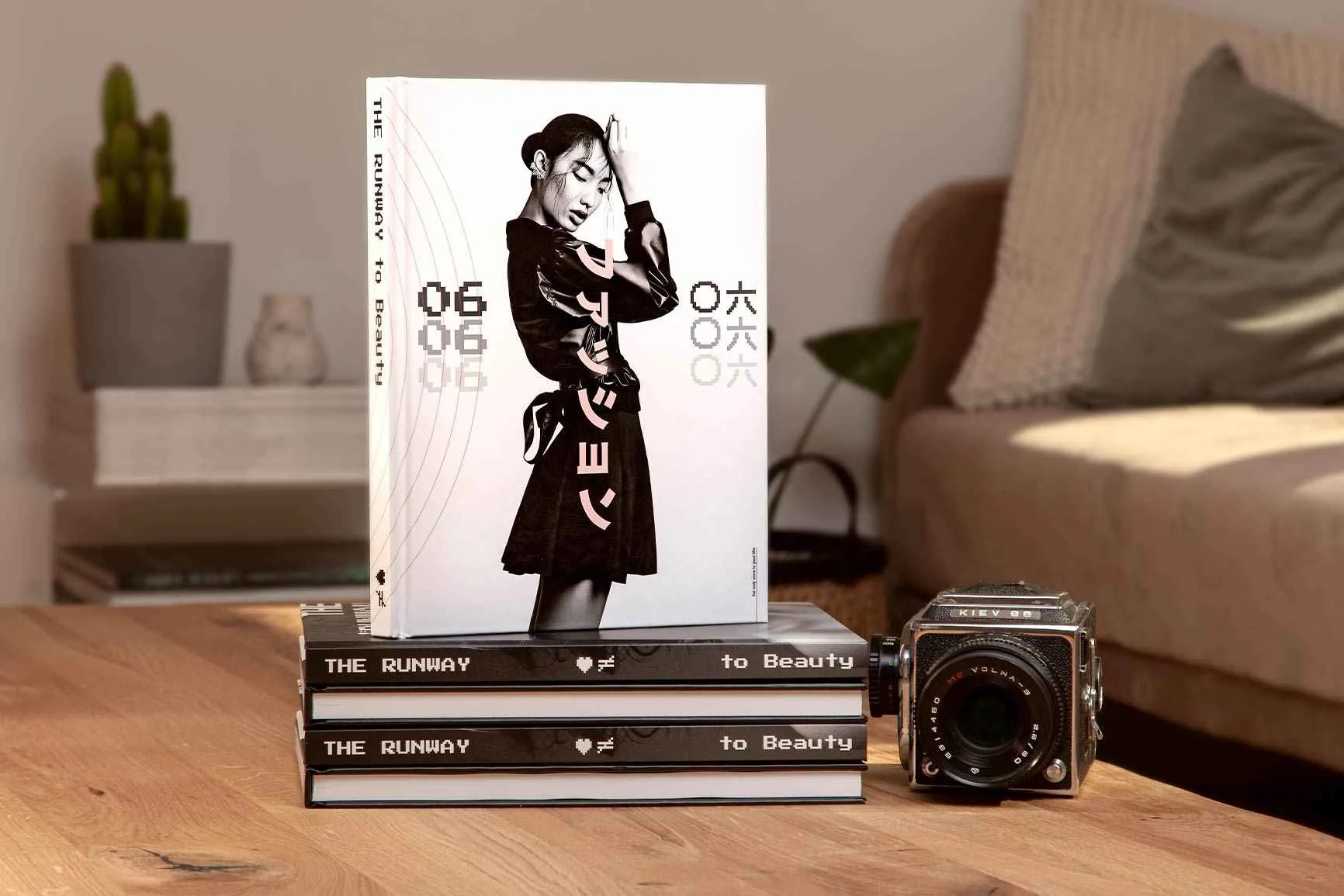 Auf einem Tisch stehen zwei Bildbände übereinander, darauf ein Bildband mit einem schwarz-weißen Cover.