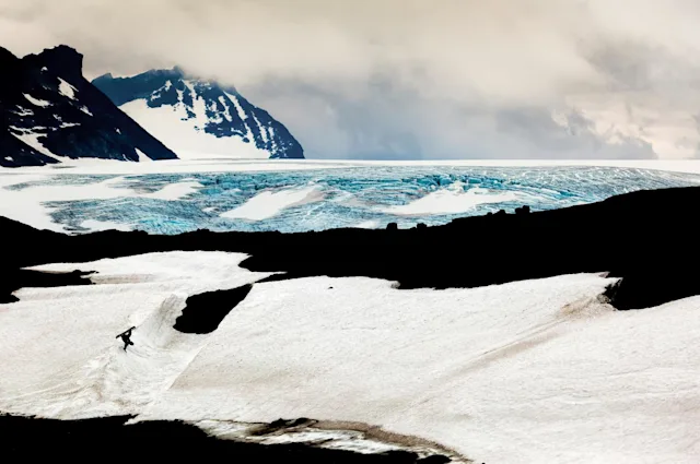 Picture of a snowy landscape at the sea with a snowboarder