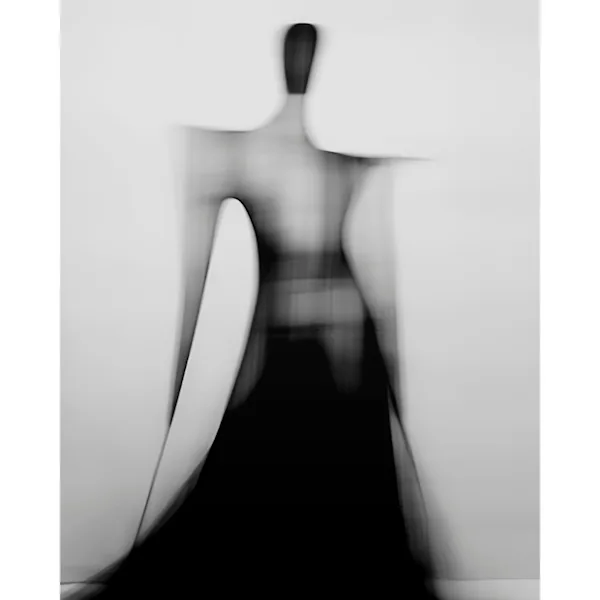 Blurred monochrome portrait of the silhouette of a woman photographed from behind