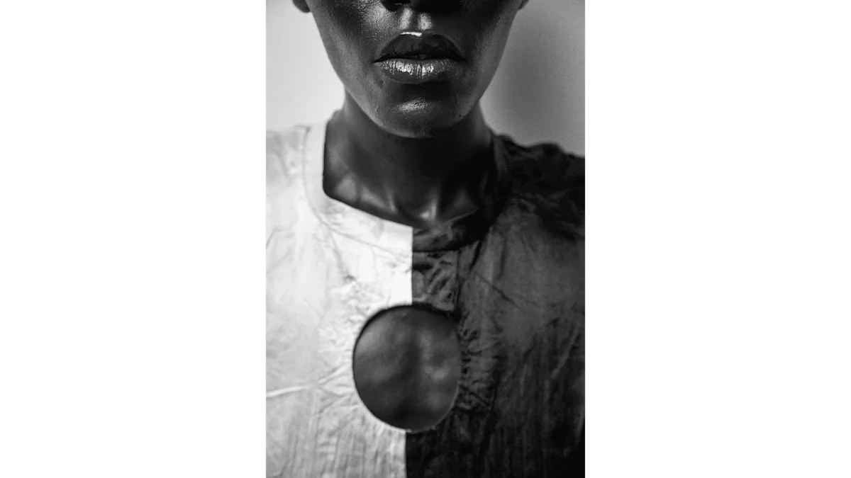 Portrait of a person, with focus on nose, mouth and chest. It is a monochrome image and the model is wearing a black and white blouse