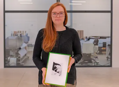 young woman with long red hairs holding a framed picture in her hands
