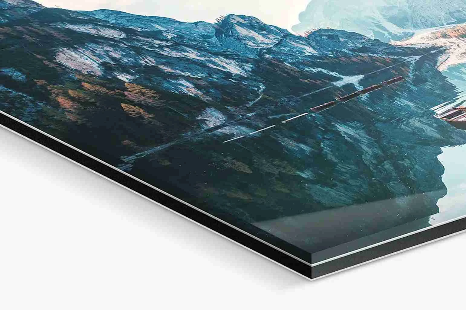 Nahaufnahme eines Fotos hinter Acrylglas mit Landschaftsbild, das Berge und Himmel zeigt.