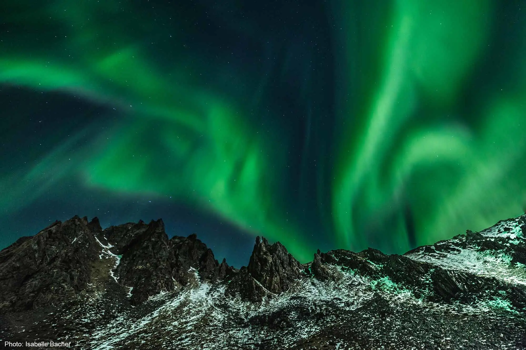 Polar lights over mountain landscape - photo by Isabelle Bacher.