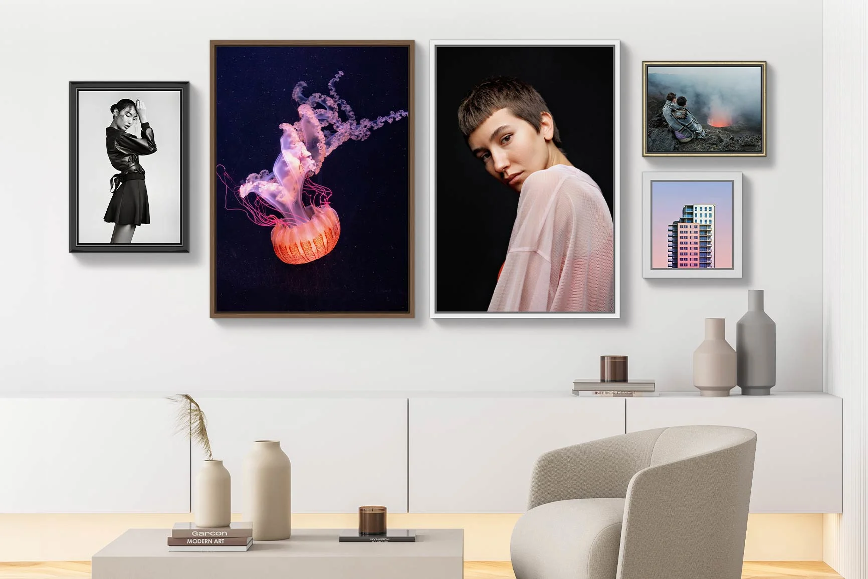 Wohnzimmer mit fünf gerahmten Bildern an der Wand, darunter eine Qualle, ein Hochhaus und andere Motive.
