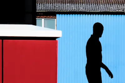 Shadow of a person on a blue wall.