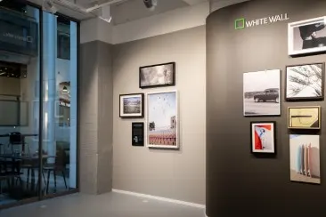Gallery wall with WhiteWall logo and various framed photographs and works of art.