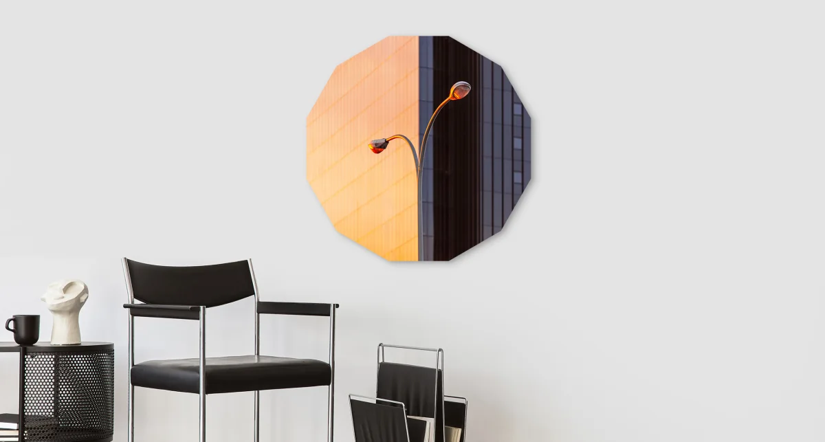 A street lamp in front of a high-rise building in the shape of a dodecagon hangs on a wall.