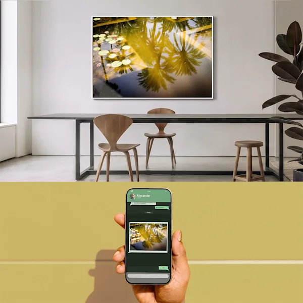 Eine geteilte Ansicht, die oben ein modernes Esszimmer mit einem großformatigen Wandbild zeigt, das Palmenreflexionen in einem Teich darstellt. Im unteren Teil hält eine Hand ein Smartphone vor einem gelben Hintergrund, auf dessen Display dasselbe Motiv in einem Chatverlauf zu sehen ist, um die einfache Bestellung von mobilen Schnappschüssen in Galeriequalität zu illustrieren.