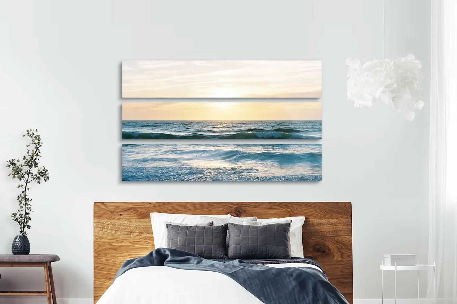 Trittico in tre parti sopra un letto raffigurante il tramonto sul mare con le onde.