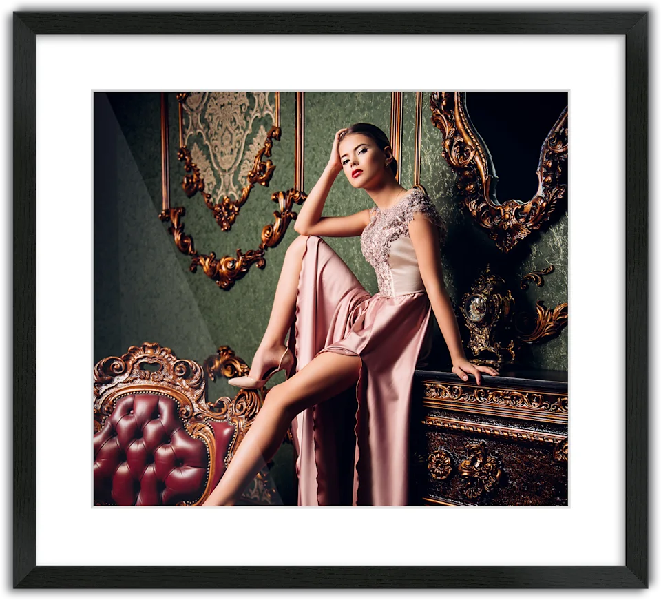 Woman in an elegant pink evening gown sitting on a piece of furniture, passe-partout frame surrounding the photo.