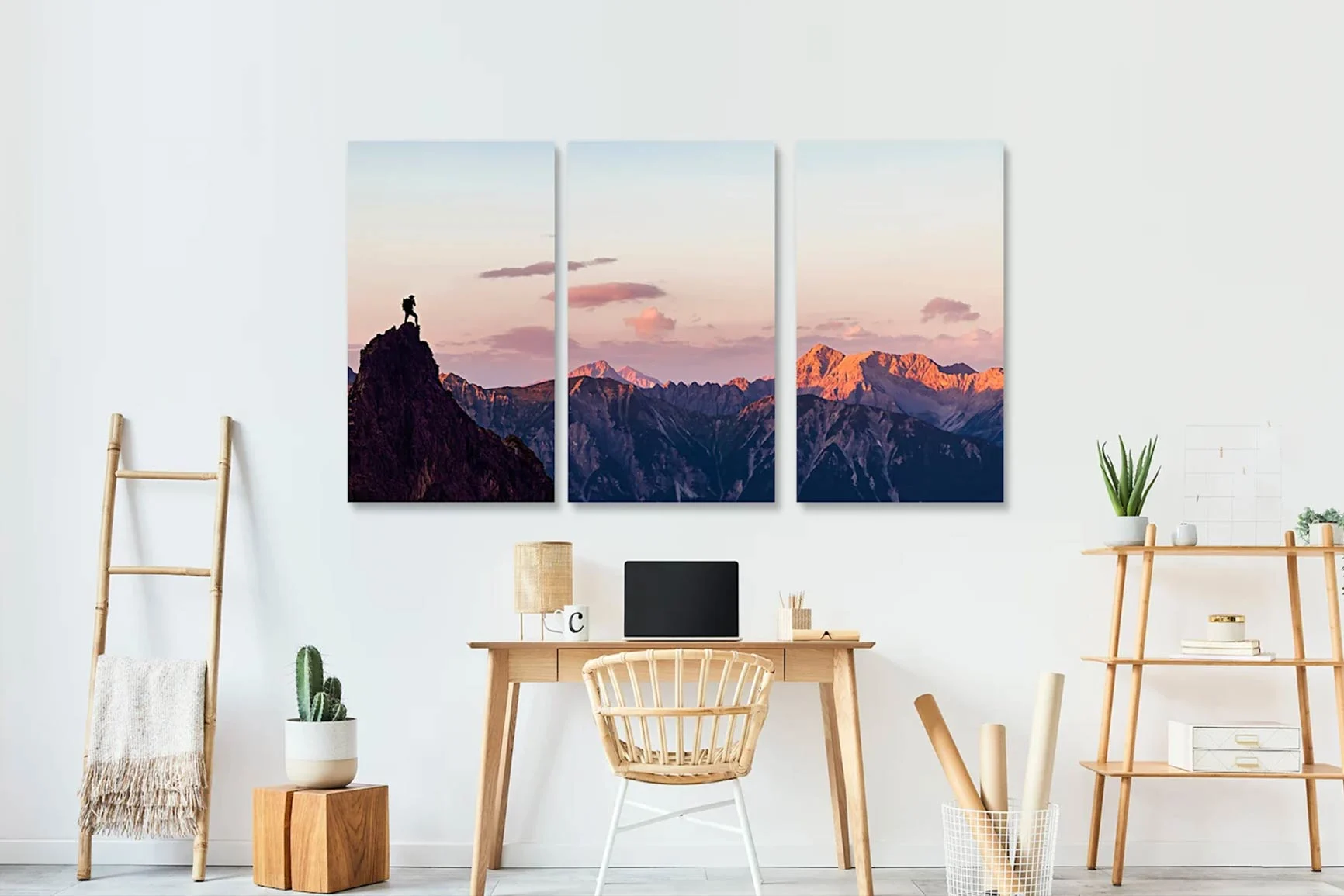 Trittico con paesaggio montano al tramonto e una persona su una roccia sopra una scrivania in una stanza luminosa.