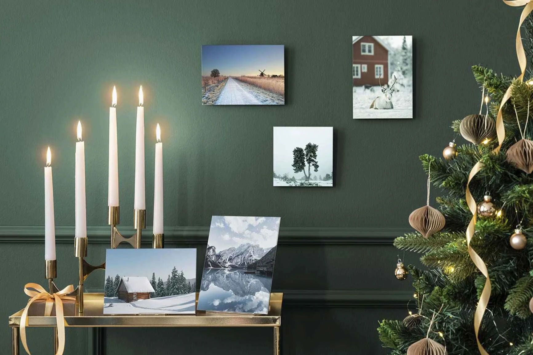 Weihnachtlich dekorierter Tisch, darauf WhiteWall Minis mit Winterlandschaften, daneben geschmückter Weihnachtsbaum.