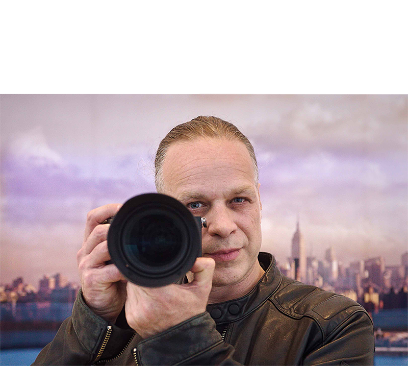 portrait of Karsten Staiger holding a camera.