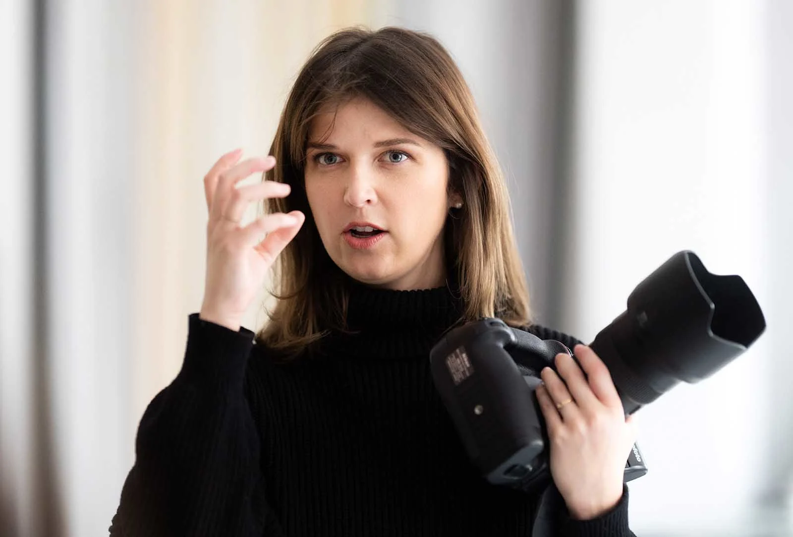 mary ruffinoni holding a camera giving instructions to someone off camera.