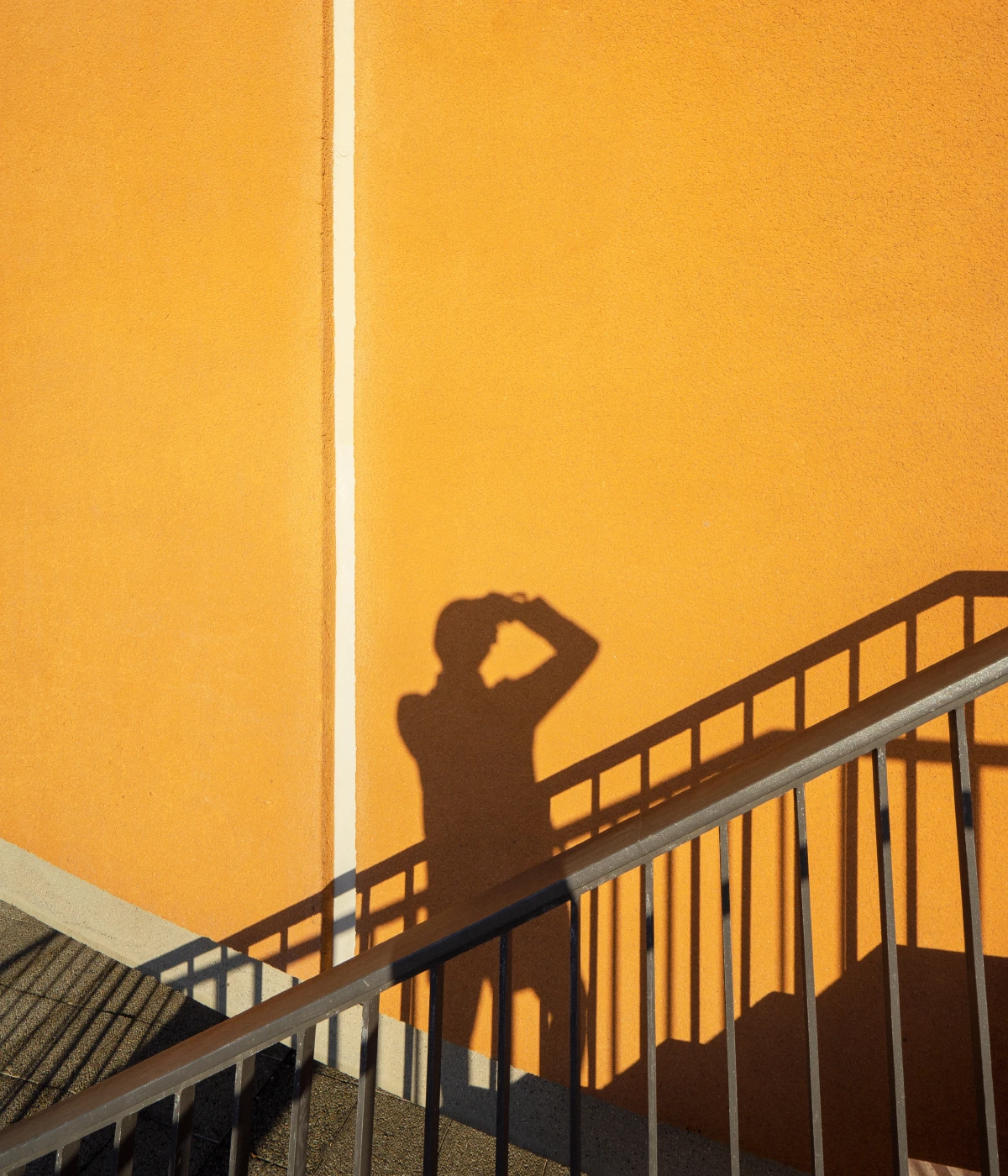 Shadow of a person on a yellow wall.