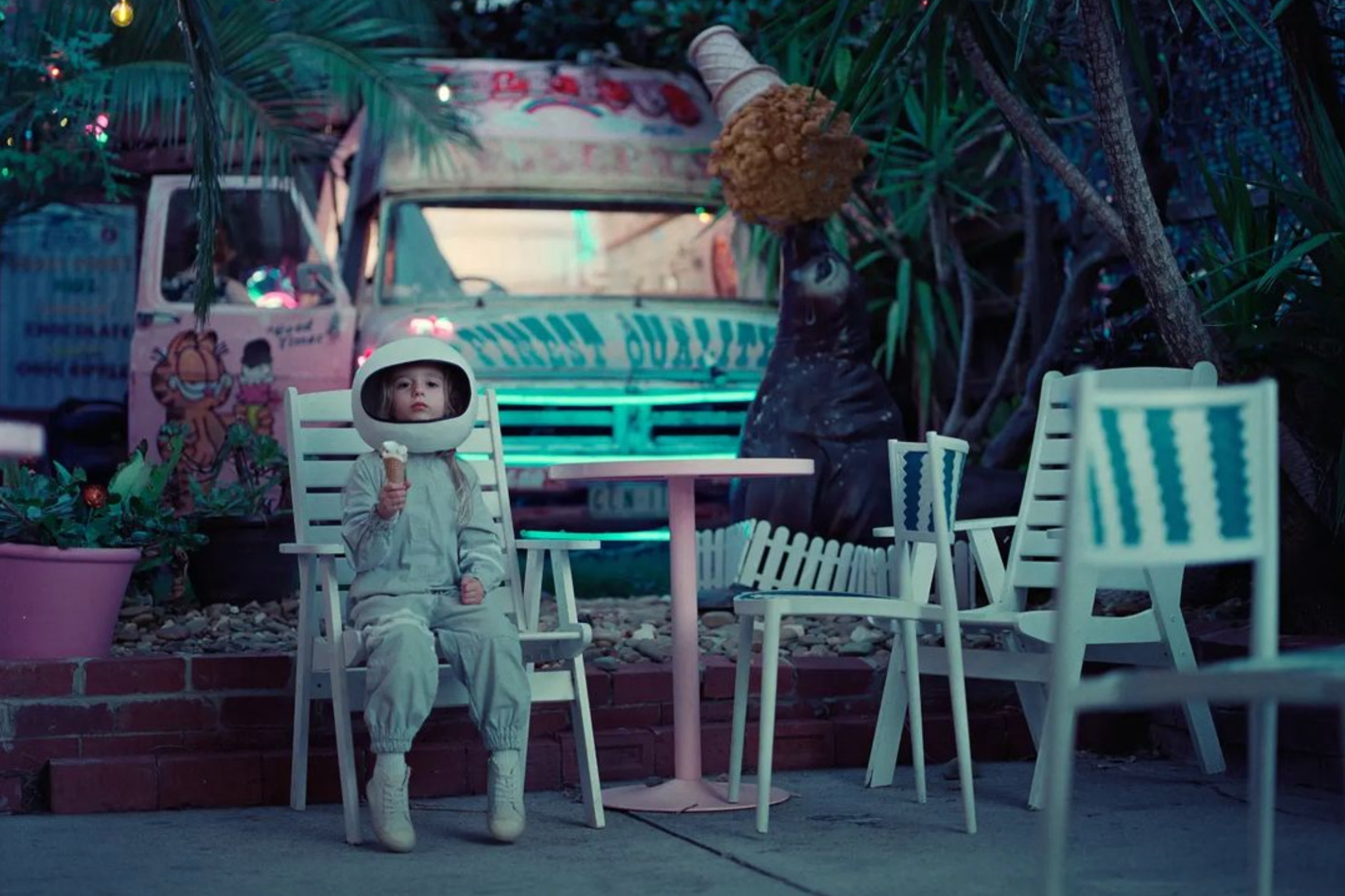 boy dressed as an astronaut sitting in a plastic chair.
