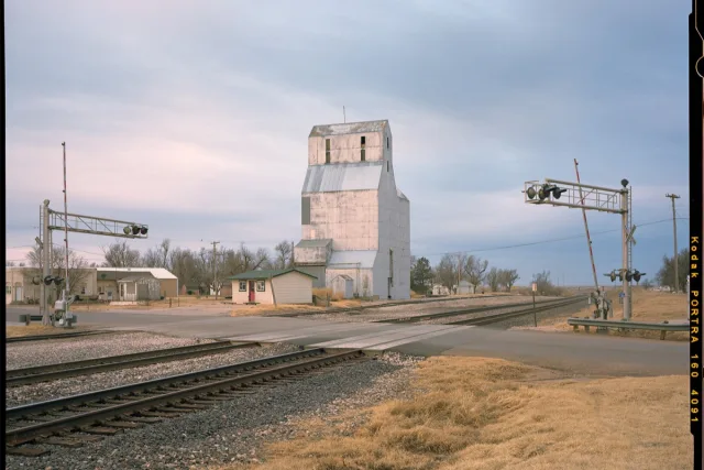 architectural photography of a farm building next to railway tracks.