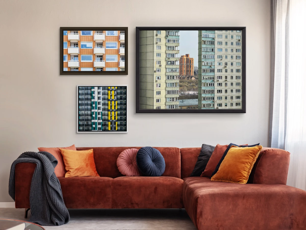 Several different motifs on photo print on alu-dibond with different frames hang on a wall in a living room.
