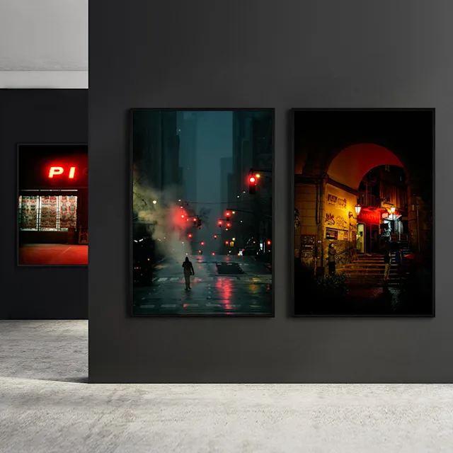 Three framed photos with night scenes on dark walls in a photo exhibition