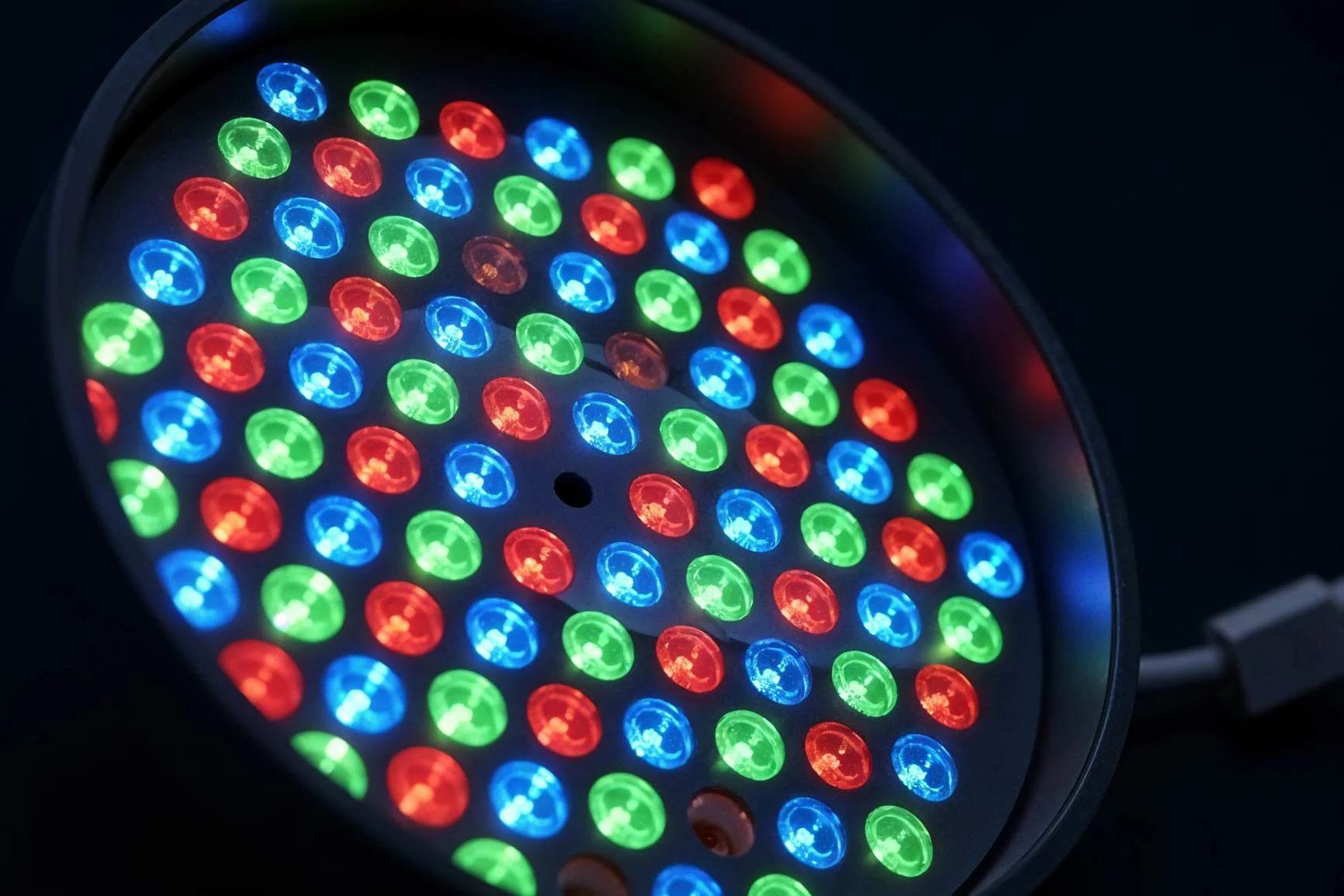 Close-up of a round RGB light with red, green, and blue LEDs arranged in a black housing.