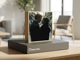 Fotolijst met een silhouet van een stel tegen een groene achtergrond, gemonteerd op een geschenkdoos met "WhiteWall" logo.