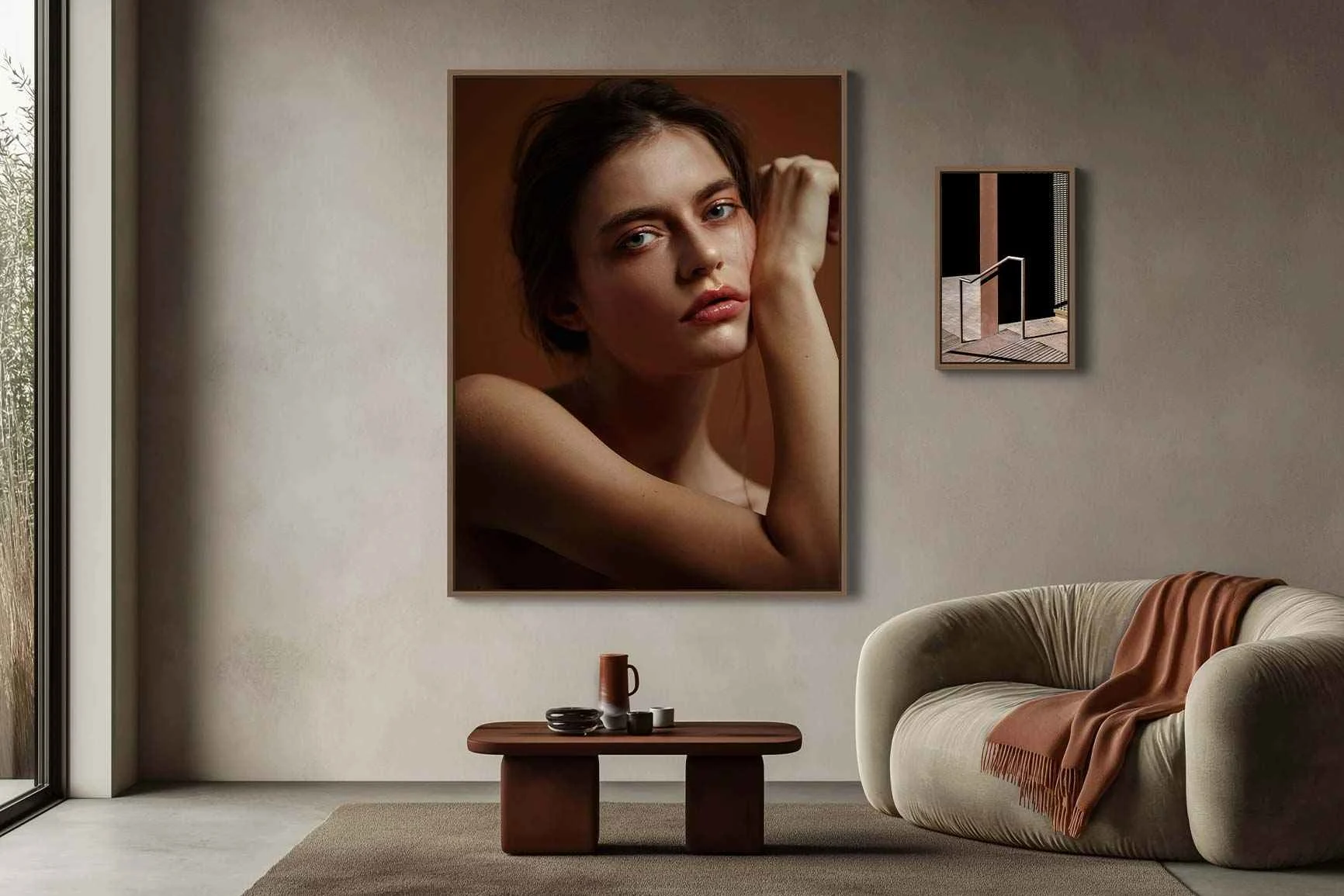 Soggiorno con un grande divano, un tavolo e due quadri incorniciati appesi alla parete, entrambi nei toni del marrone.