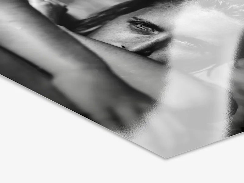 Close-up of a photo print on baryta paper with a black-and-white photograph of a person.