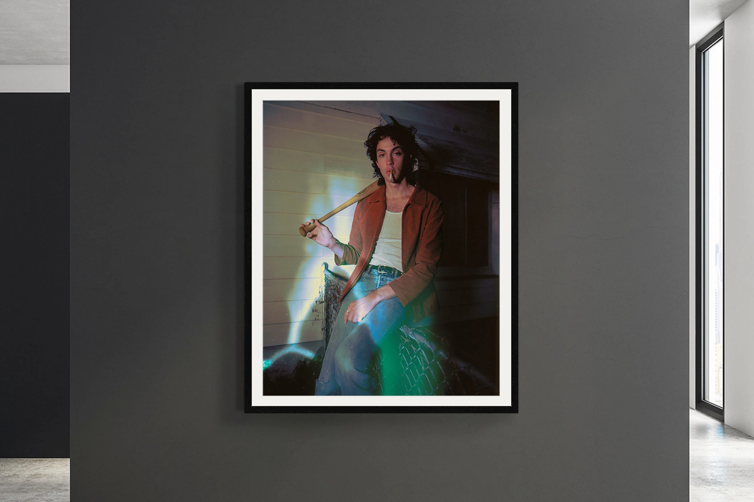 Young person with baseball bat, smoking, leaning or sitting against a fence, with colorful light rays.