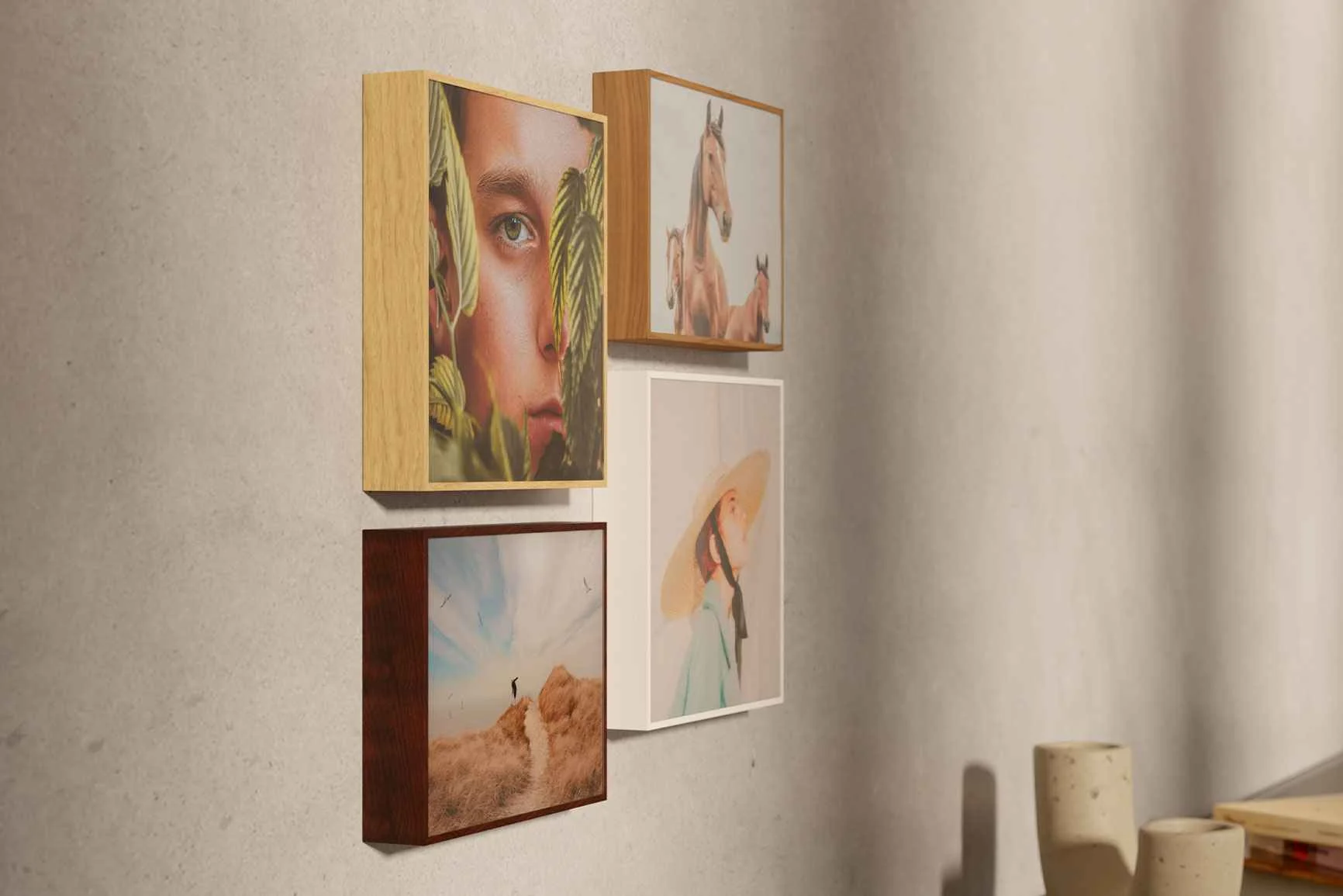 Vier quadratische Bilder in einer ArtBox aus Holz hängen an einer Wand