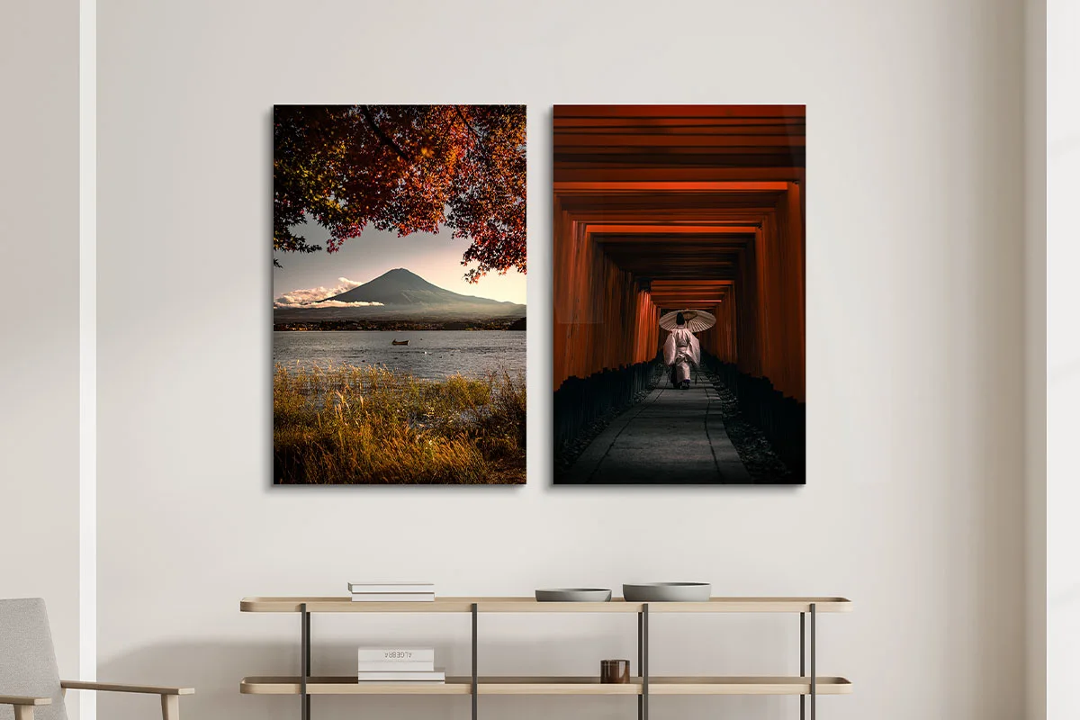 Two wall art pieces: left, mountain with lake and trees; right, person with umbrella.
