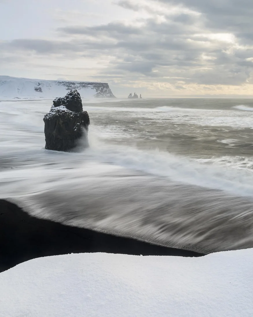 Waves crashing against a lone stone.