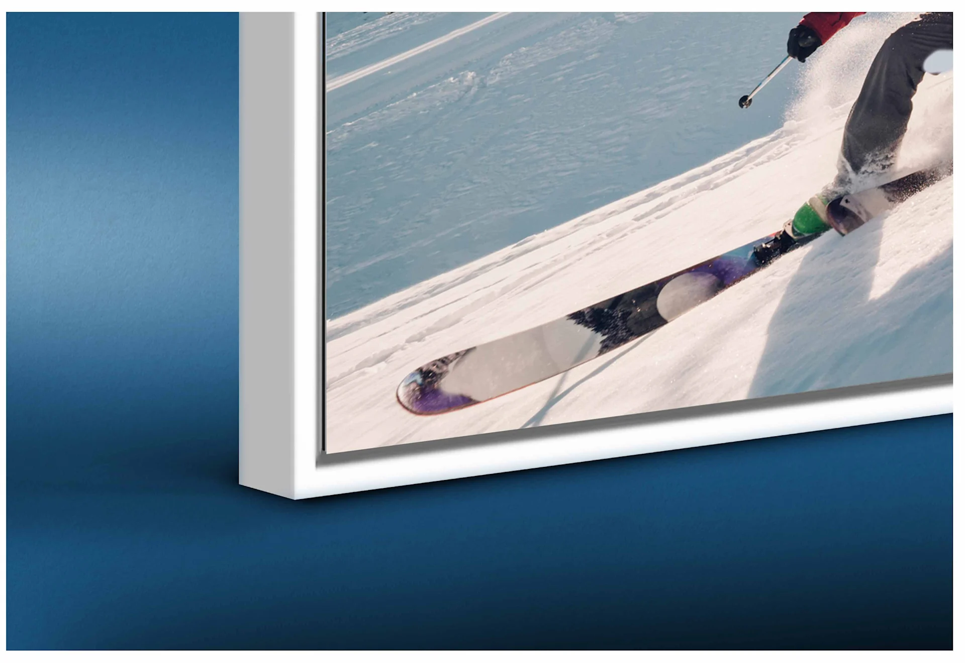 A close-up of the bottom-left corner of a modern white floater frame. The image depicts speed skaters in motion. A distinct gap (the shadow gap) is visible between the edge of the print and the inner frame, giving the artwork a floating appearance.