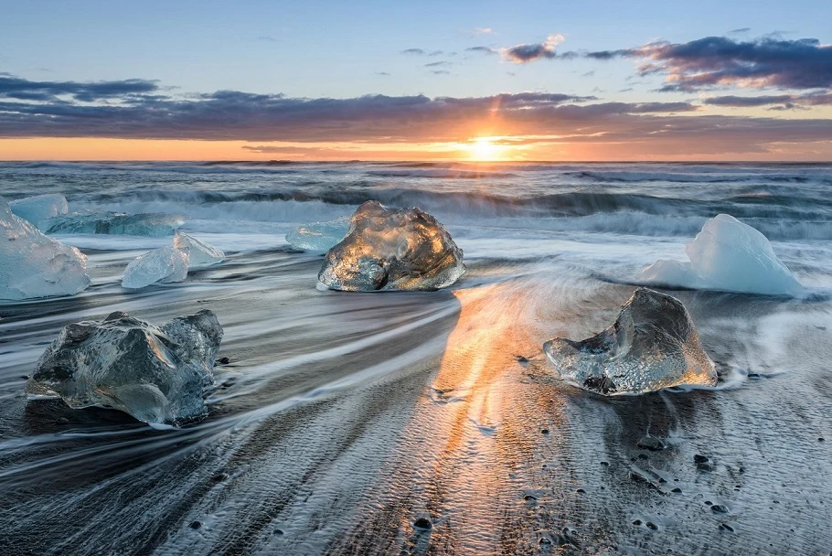 icy beach in front of a sunrise.