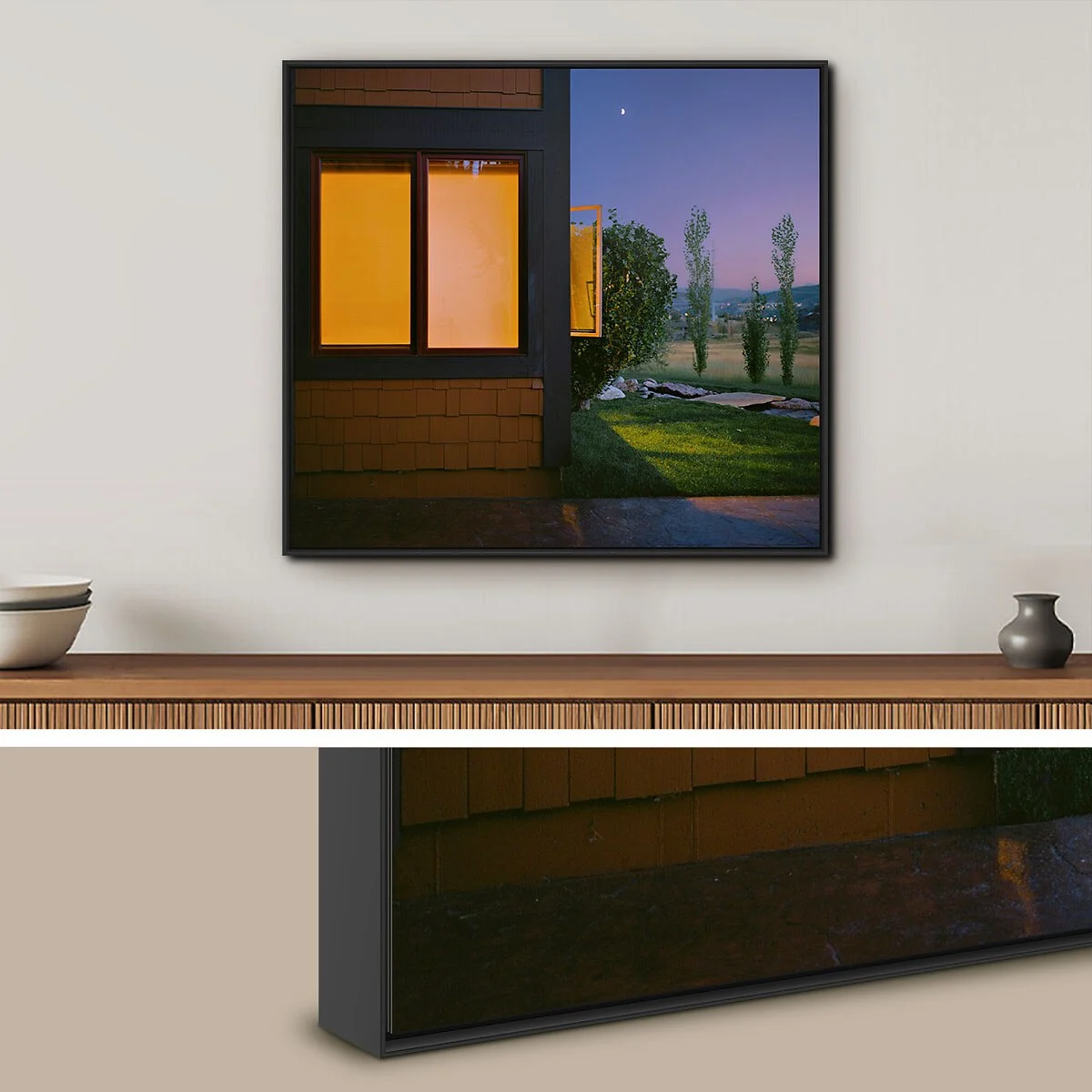 Schwarze Aluminium-ArtBox zeigt ein Bild mit einem beleuchteten Fenster und einer Landschaft mit Bäumen bei Dämmerung.