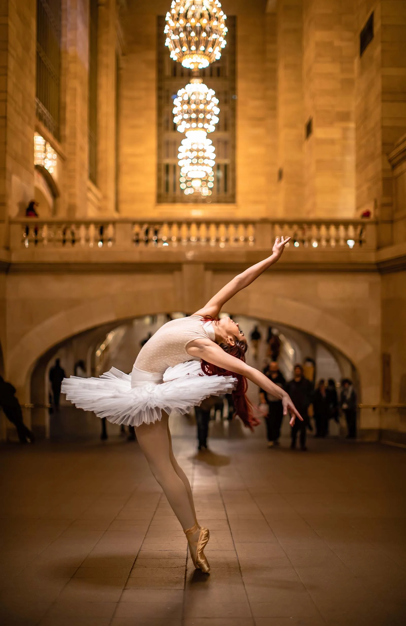 ballet dancer posing in a train station.