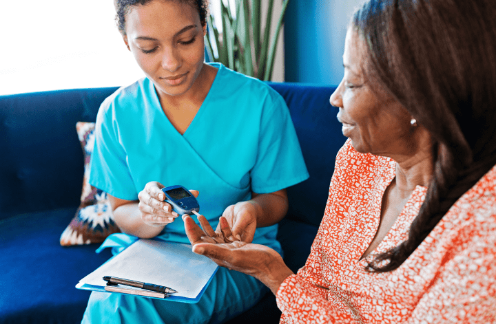 Doctor checking a woman’s blood glucose level.