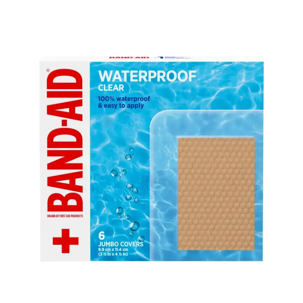 A bundle of six Band-Aid Brand Waterproof Clear Jumbo Covers. Imagine a close-up of a tan, textured bandage, set against a serene blue water backdrop. Each bandage is a generous 8.9 cm x 11.4 cm (3½ in x 4 ½ in).