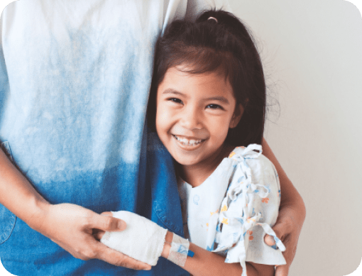 Young girl hugging adult with IV in arm