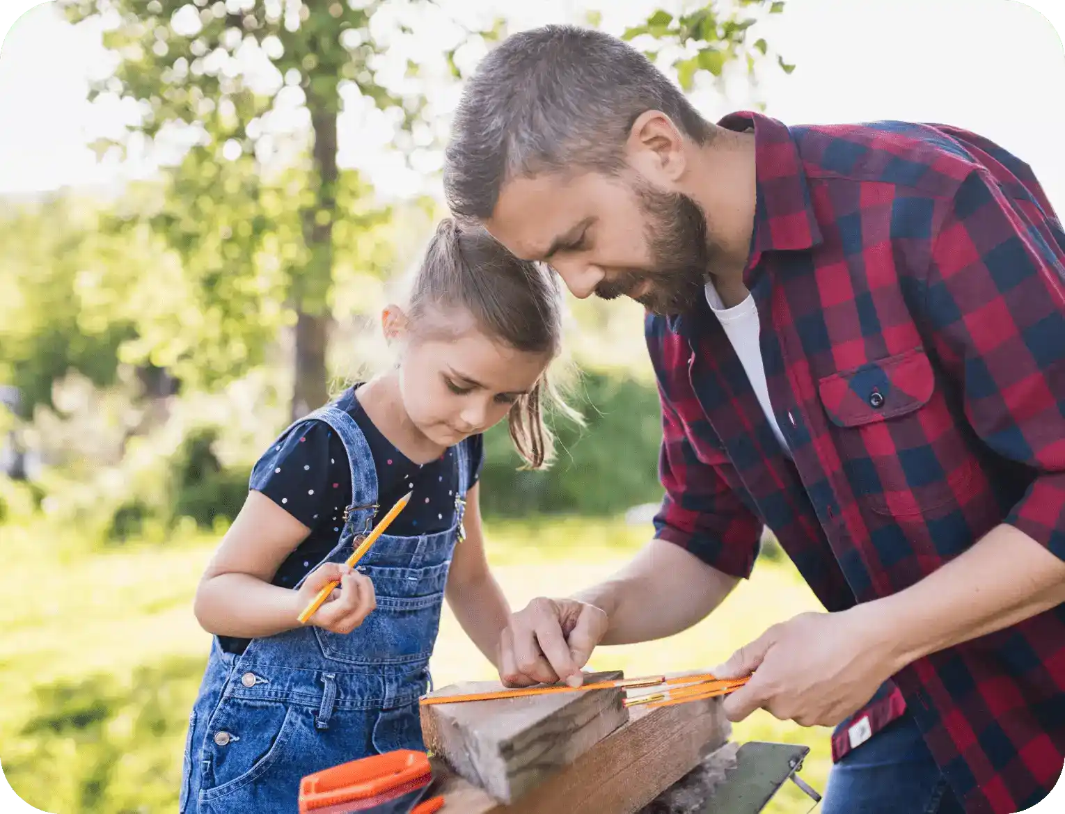 Man teaching young girl basic woodworking skills.