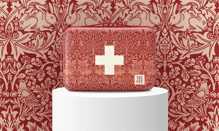 BAND-AID®️ Brand case featuring an intricate red and cream floral pattern, inspired by William Morris, with a white cross symbol and The Met logo, part of THE MET collaboration.